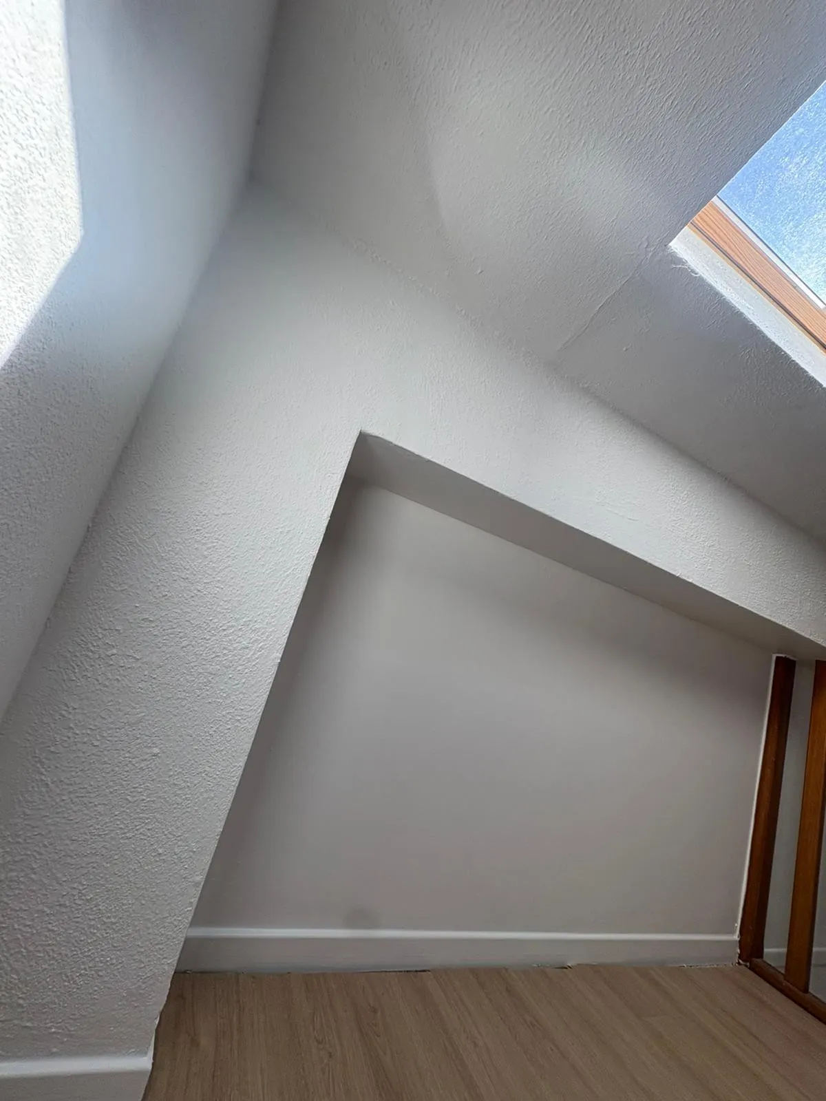 Chambre sous combles avec fenêtre de toit repeinte