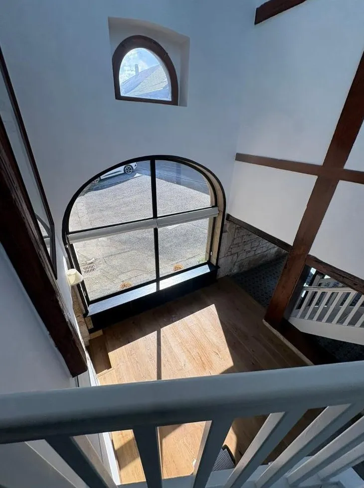 Fenêtre cintrée et escalier après rénovation